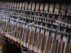 Photo of solenoides beneath the keyboard of a piano